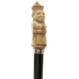 AN EARLY 20TH CENTURY WALKING CANE, the ivory pommel carved as an imperious looking queen wearing