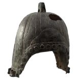 A CHINESE BRONZE ZHOU DYNASTY HELMET, the bronze skull, with ribbed and riveted decoration,