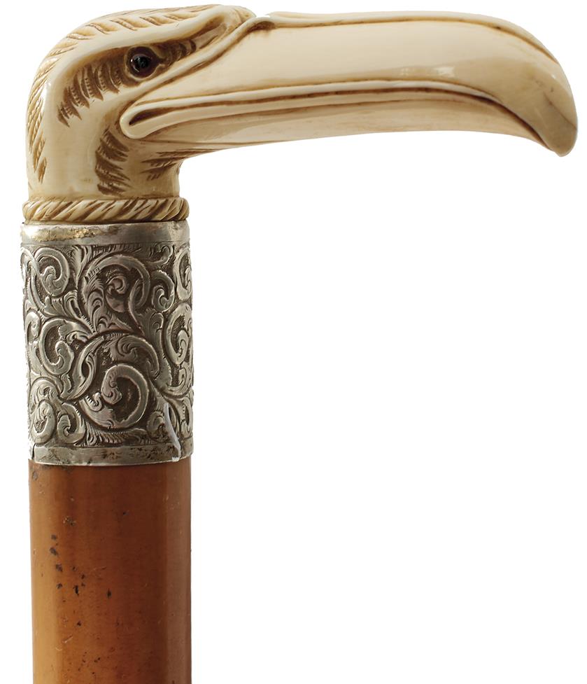 A LATE 19TH CENTURY WALKING STICK, the ivory handle carved as a stylised eagle's head, above white