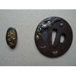 Asiatica.-Tsuba. Gusseisen mit Buntmetallauflage. Japan, 19. Jahrhundert. Durchmesser: ca. 7 cm.