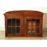 A Jugendstil display cabinet with arched top, two doors and cutted glass windows with bronze grid;