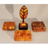 Lot of four amber objets including thee boxes with lids and one paper weight in shape of a feather