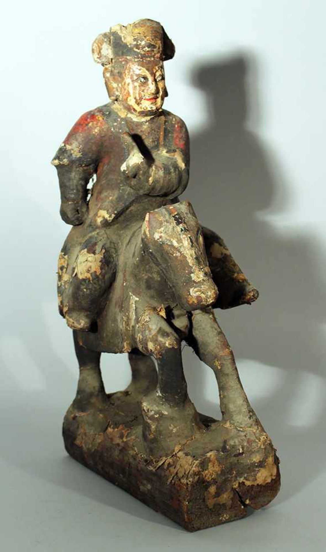 Chinese wooden sculpture of a horse rider with painted and decorated textile cover; damages and
