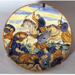 Italian ceramic dish painted in the centre with a battle scene; thin light border, on the