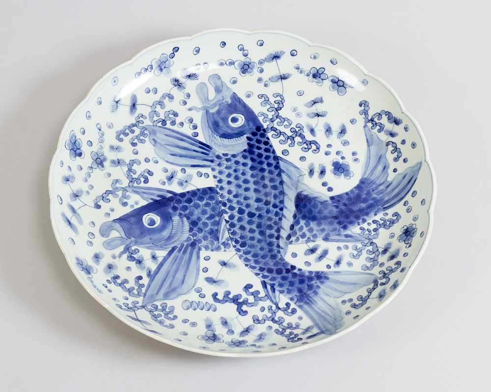 Japanese porcelain dish with blue painted fishers and decorations on white ground, glazed; waved