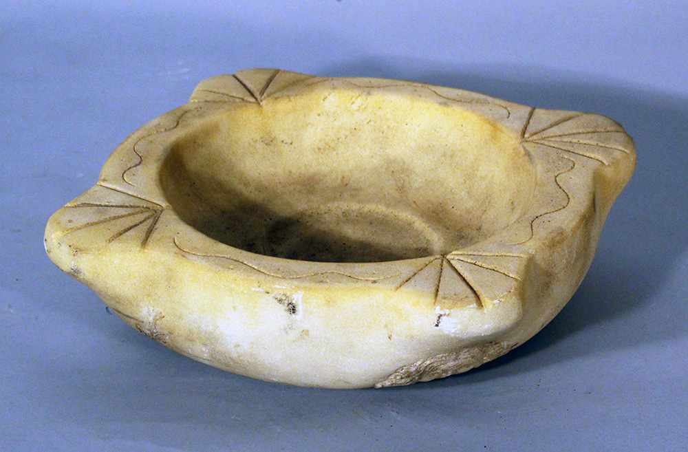 Small marble basin in Roman ancient style with sculpted Minerva heads and leaves; on the upper