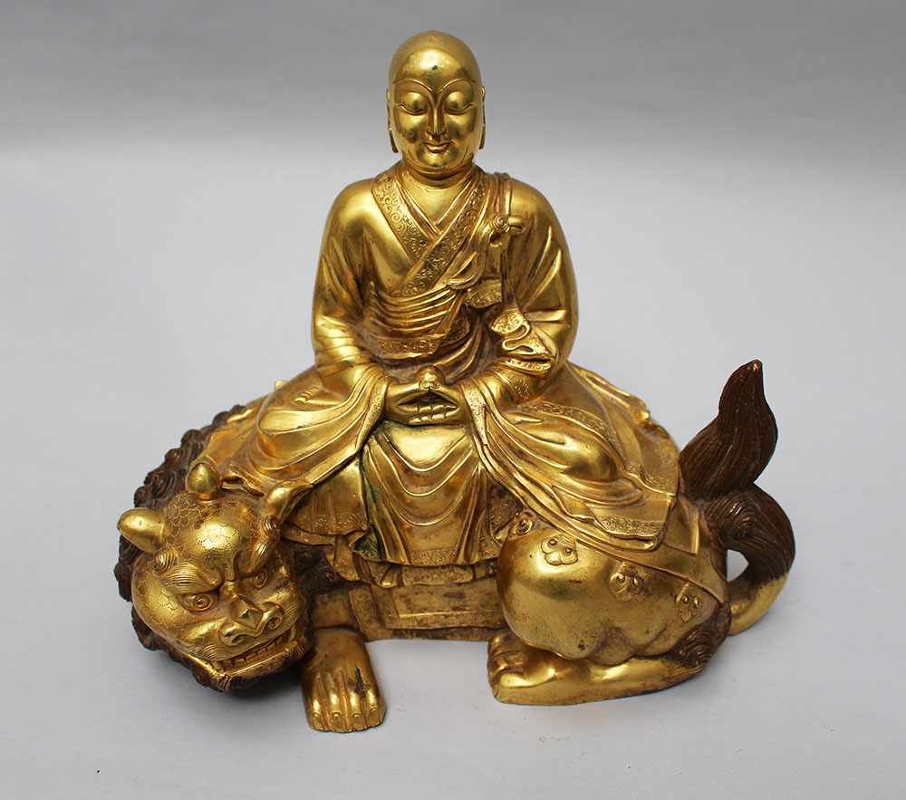 Chinese gilted bronze sculpture of Buddha in sitting position with falted mantle and his hands