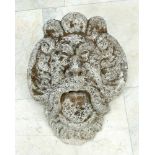 Large grotesque stone mask, with open mouth, naturalistic face and decorated with volutes and