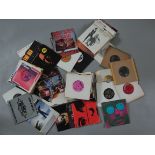 A small vintage box of 7 inch vinyl records (singles) including Bruce Springsteen, The Stranglers,