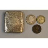 A decorated silver cigarette case with three coins, one a silver crown,