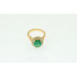 An 18ct H/M emerald and diamond ring, the overall cut emerald approx 3.