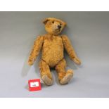 A straw filled teddy bear with a hump back, height approx. 38cm. G.