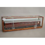 O Gauge. A maroon Railway Carriage housed in a glazed case.