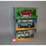 Three boxed Land Rover diecast models in 1:18 scale, including Police version,