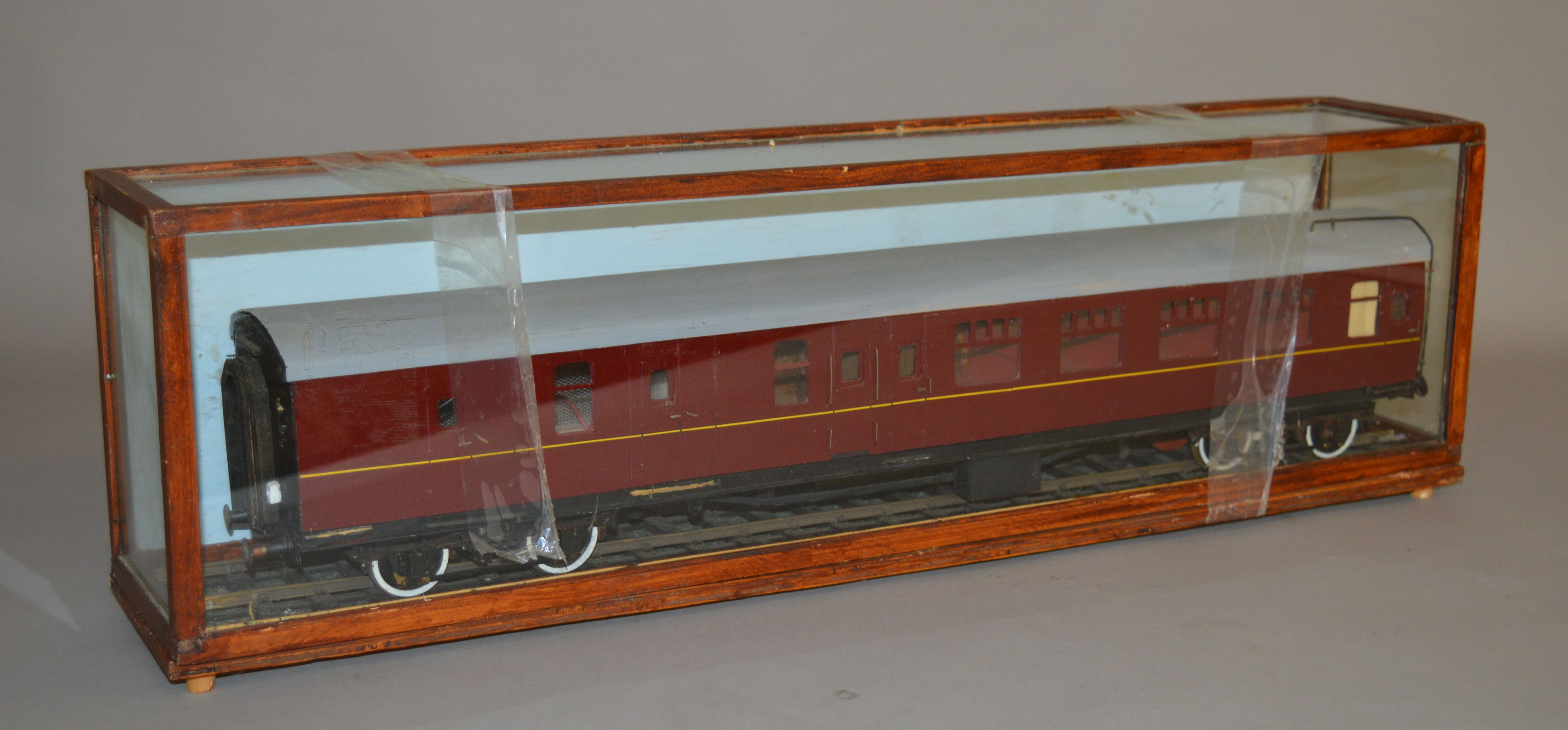 O Gauge. A maroon Railway Carriage housed in a glazed case.