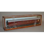 O Gauge. A maroon Railway Carriage housed in a glazed case.