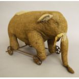 Vintage pull along elephant on cast wheels, height approx. 30 cm.