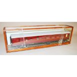 O Gauge. A maroon Railway Carriage housed in a glazed case.