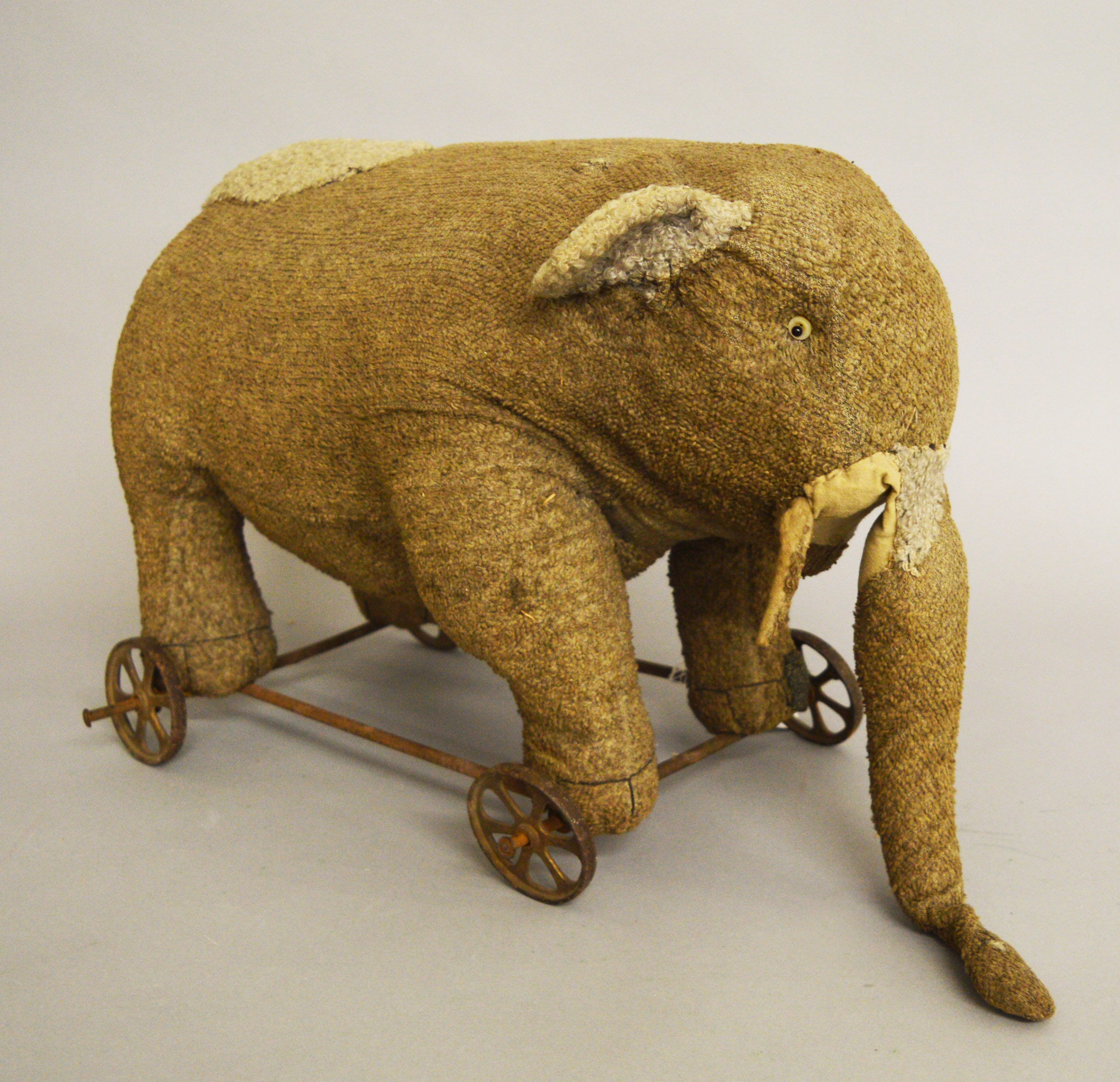 Vintage pull along elephant on cast wheels, height approx. 30 cm.