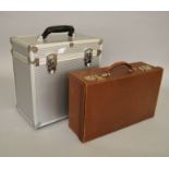 A small vintage travel suitcase together with a modern padded flight-case.