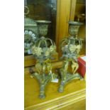 A pair of Regency ormulu candlesticks supported by mythical beasts