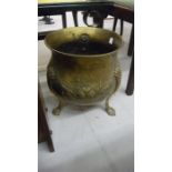 A brass cauldron shaped coal bin on three legs