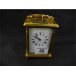 A brass carriage clock, has chips to face