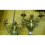 A pair of ornate two branch cherub wall lights