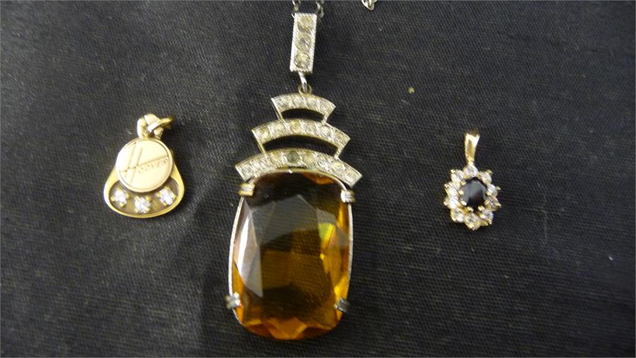 A 10 ct gold pendant set with 3 small diamonds and two others