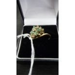 An emerald and diamond cluster/dress ring set in 9ct gold