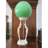 An Art Deco lamp formed from two nudes holding aloft a mottled green globe, Reg'd number indistinct