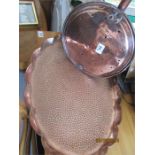 A hand beaten oval copper tray along with a copper warming pan