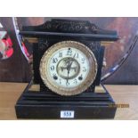 A black slate mantle clock with ornate enamelled dial and gilt surround