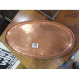 A Hugh Wallace ( Altringham) oval Arts & Crafts copper tray, stamped with monogram