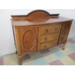 An Edwardian bow fronted sideboard with three central drawers, on claw and ball feet