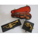 Three miniature cased musical instruments- A French horn, a violin and a trumpet