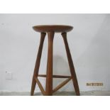 A tall 3 legged wooden stool