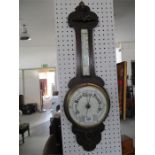 A carved oak aneroid banjo barometer