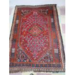 A handwoven red ground rug