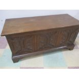 An oak blanket box with carved decoration to front