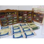 A quantity of Lledo Days Gone diecast cars in 2 display cabinets