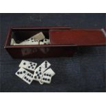 A full miniature bone set of dominoes in mahogany case- case measures 5.2cm length