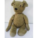 A vintage straw filled teddy bear with hump to back