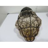 A vintage glass lampshade with wire decoration