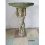 A bird bath with cherub support