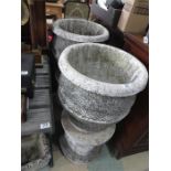 A large pair of concrete urns on plinths