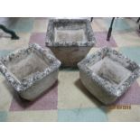 A pair of concrete garden pots and one other