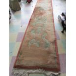 A red ground Chinese runner decorated with dragons- 176 cm x 70 cm