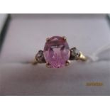 A diamond and oval pink sapphire three stone ring set in 10ct gold