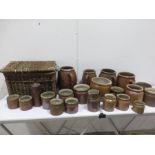 A quantity of stoneware pots, mainly French, along with a wicker basket